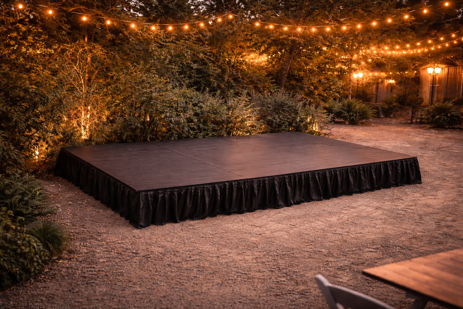 Portable stage set up outdoors at a Charlotte NC event with string lights